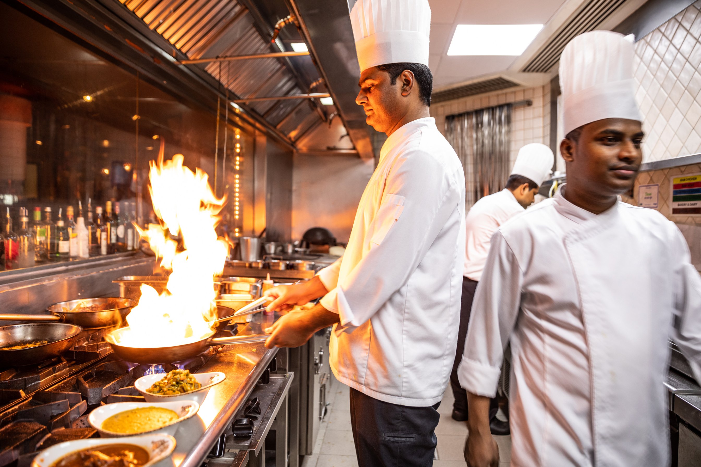 Indian chefs cooking in a professional kitchen of a gourmet restaurant